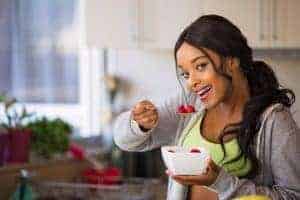 la mujer come ensalada de frutas