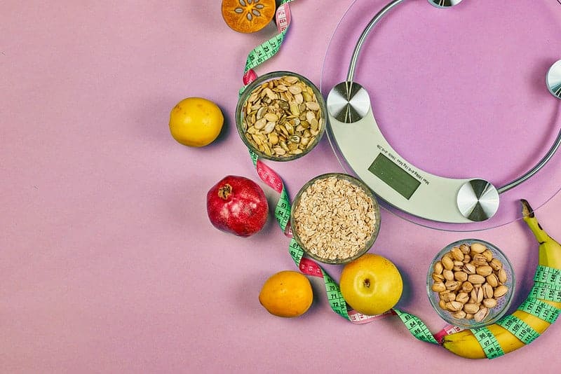 básculas de cocina y alimentos dietéticos saludables (granos, frutas)