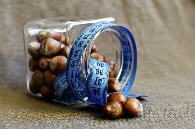 un frasco de nueces envuelto en una medida de sastre