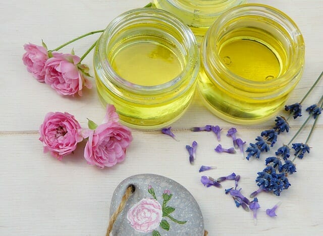 Aceites cosméticos en tarros, junto a flores frescas