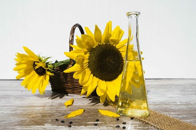  Un frasco de aceite junto a girasoles