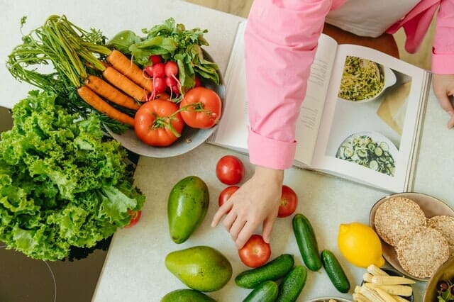  Un libro de cocina y verduras en la mesa