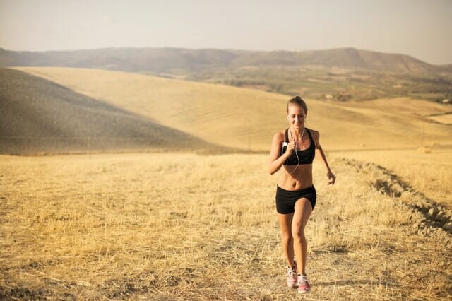 una mujer corre por el campo