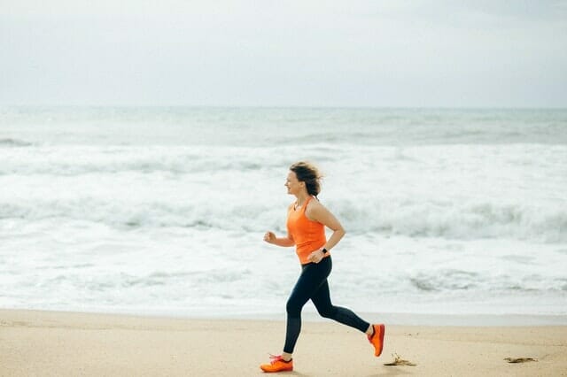 mujer corre en la playa