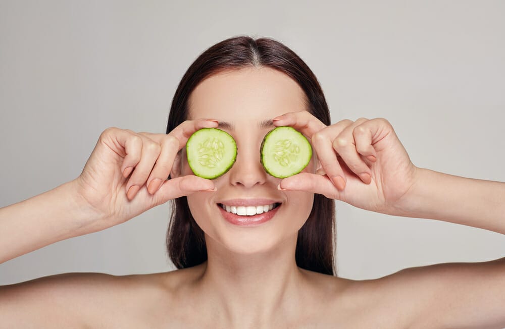 mujer con rodajas de pepino en los ojos