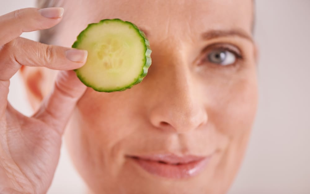 Una mujer se lleva una rodaja de pepino al ojo